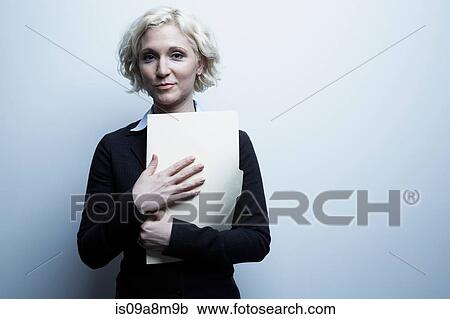 Studio portrait of businesswoman holding file View Large Photo Image Stock Image - Studio portrait of businesswoman holding file. Fotosearch