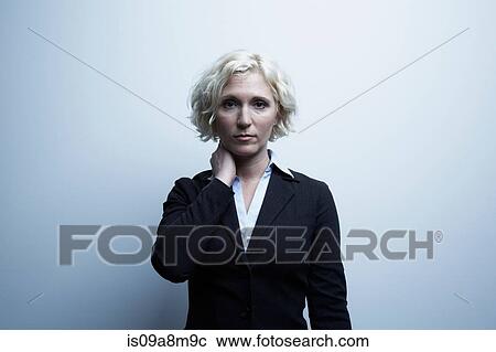 Stock Image - Studio portrait of businesswoman with hand on neck. Fotosearch