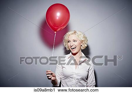 Studio portrait of mature woman with red balloon View Large Photo Image Stock Image - Studio portrait of mature woman with red balloon. Fotosearch