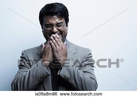 Studio portrait of mid adult male with hands over mouth laughing View Large Photo Image Stock Photograph - Studio portrait of mid adult male with hands over mouth laughing. Fotosearch
