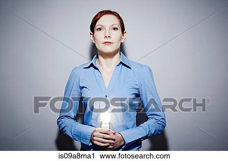 Studio portrait of young business woman holding lit lightbulb View Large Photo Image Stock Image - Studio portrait of young business woman holding lit lightbulb. Fotosearch