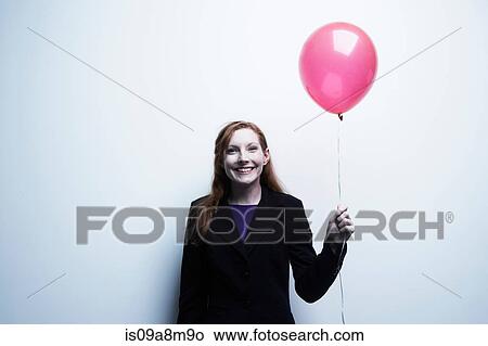 Studio portrait of young businesswoman holding red balloon View Large Photo Image Picture - Studio portrait of young businesswoman holding red balloon. Fotosearch