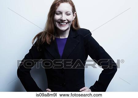 Stock Image - Studio portrait of young businesswoman smiling. Fotosearch