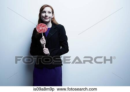 Studio portrait of young businesswoman holding red lollipop View Large Photo Image Stock Photography - Studio portrait of young businesswoman holding red lollipop. Fotosearch