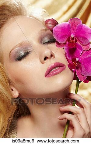 Studio portrait of young woman holding orchid stem View Large Photo Image Stock Photograph - Studio portrait of young woman holding orchid stem. Fotosearch