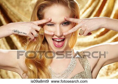 Stock Photo - Studio portrait of young woman with hand tattoo. Fotosearch
