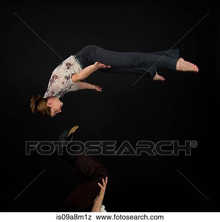 Studio shot of acrobats performing mid air View Large Photo Image Stock Photo - Studio shot of acrobats performing mid air. Fotosearch