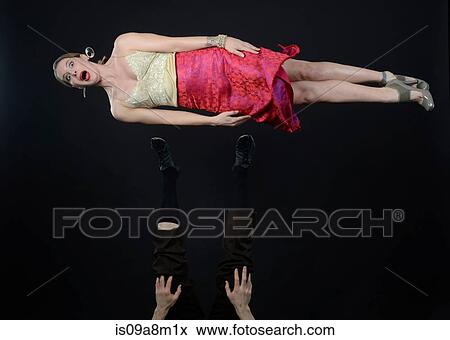 Studio shot of female acrobat mid air, lying on side View Large Photo Image Stock Photo - Studio shot of female acrobat mid air, lying on side. Fotosearch
