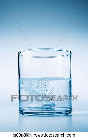 Stock Image - Tablet fizzing in glass of water. Fotosearch