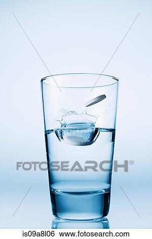 Stock Photograph - Tablets falling in glass of water. Fotosearch