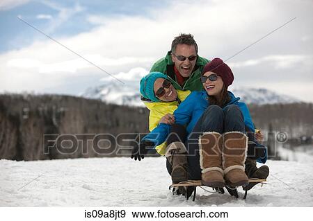 Three friends sitting on sledge in snow View Large Photo Image Stock Photo - Three friends sitting on sledge in snow. Fotosearch