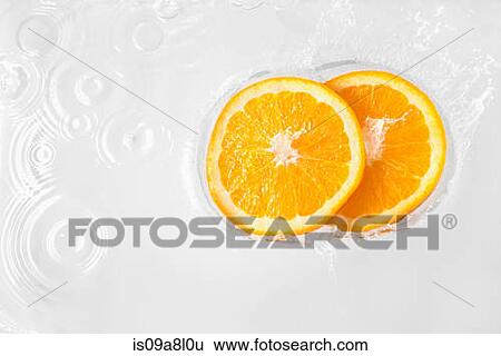Two slices of orange floating in liquid View Large Photo Image Stock Photograph - Two slices of orange floating in liquid. Fotosearch