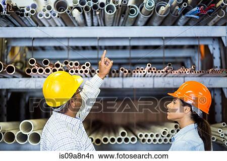 Two warehouse workers in front of shelves View Large Photo Image Picture - Two warehouse workers in front of shelves. Fotosearch