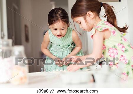 Stock Photo - Two young sisters making pastry. Fotosearch