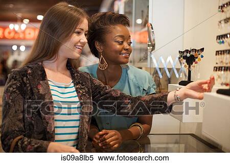 Two young women looking at earrings in vintage shop View Large Photo Image Stock Photography - Two young women looking at earrings in vintage shop. Fotosearch