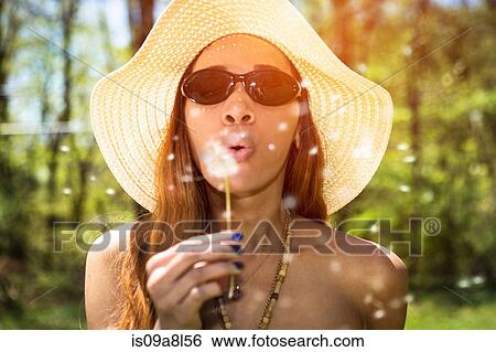Woman blowing dandelion clock View Large Photo Image Stock Photograph - Woman blowing dandelion clock. Fotosearch