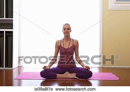 Woman doing yoga sitting cross legged View Large Photo Image Stock Image - Woman doing yoga sitting cross legged. Fotosearch