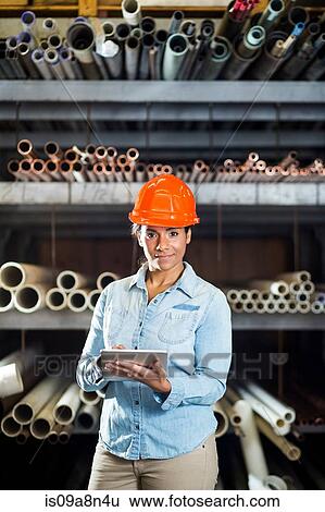 Stock Photograph - Woman in warehouse with digital tablet. Fotosearch