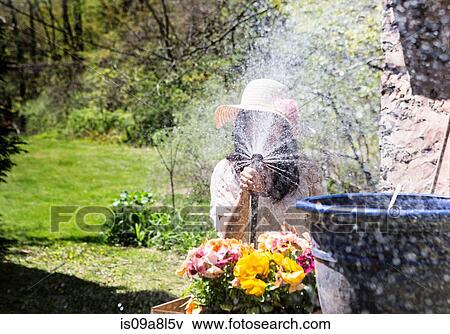 Woman spraying water towards camera View Large Photo Image Stock Photo - Woman spraying water towards camera. Fotosearch