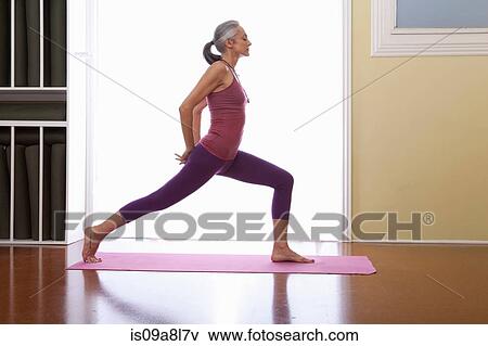 Stock Photo - Woman stretching legs with hands behind back. Fotosearch