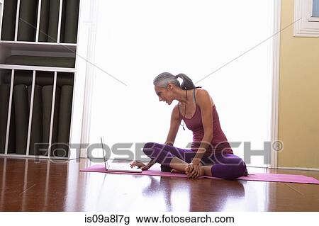 Woman using laptop sitting cross legged View Large Photo Image Stock Image - Woman using laptop sitting cross legged. Fotosearch