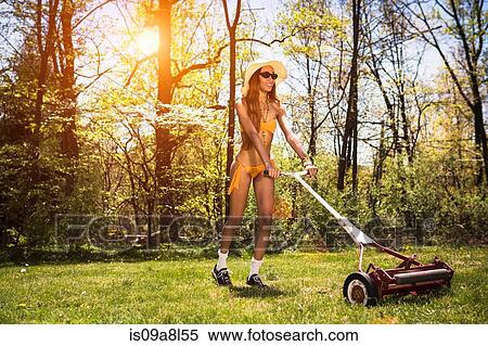 Woman wearing bikini mowing grass View Large Photo Image Stock Photography - Woman wearing bikini mowing grass. Fotosearch