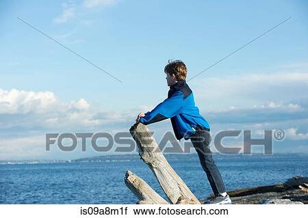 Stock Image - Young boy looking out from Bainbridge Island, Washington State, USA. Fotosearch