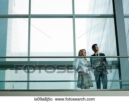 Picture - Young business colleagues standing in modern building. Fotosearch