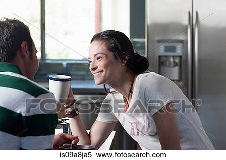 Young couple enjoying coffee in kitchen, smiling View Large Photo Image Stock Photography - Young couple enjoying coffee in kitchen, smiling. Fotosearch