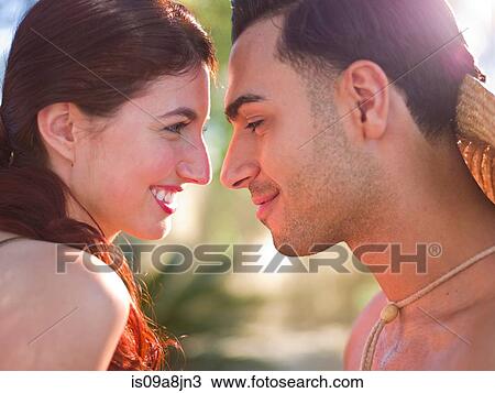 Stock Image - Young couple face to face, smiling. Fotosearch