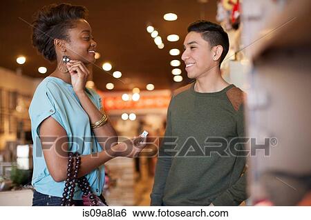 Young couple in vintage shop, woman trying on earrings View Large Photo Image Stock Photograph - Young couple in vintage shop, woman trying on earrings. Fotosearch