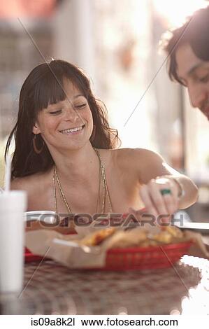 Young couple sharing snack in outdoor cafe, portrait View Large Photo Image Stock Image - Young couple sharing snack in outdoor cafe, portrait. Fotosearch