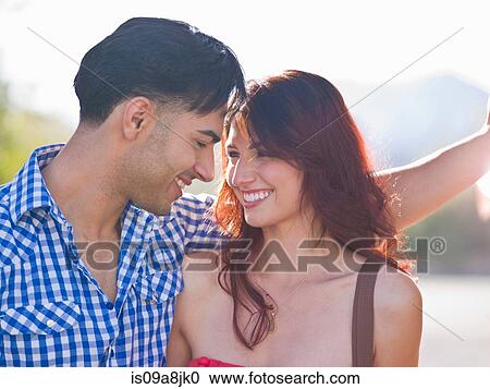 Young couple smiling at each other, close up View Large Photo Image Stock Image - Young couple smiling at each other, close up. Fotosearch