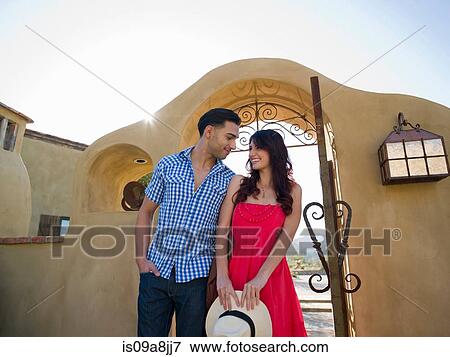 Young couple smiling together at entrance to villa View Large Photo Image Stock Photo - Young couple smiling together at entrance to villa. Fotosearch