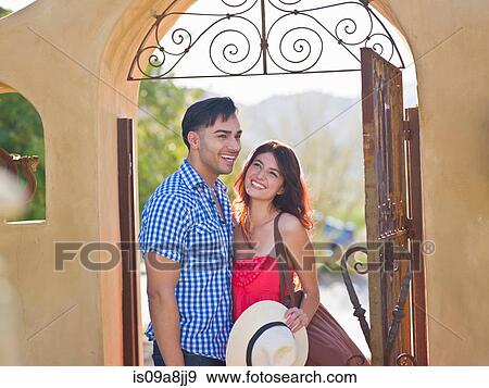Young couple smiling together at entrance to villa View Large Photo Image Stock Photo - Young couple smiling together at entrance to villa. Fotosearch