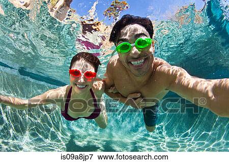 Young couple swimming underwater in pool View Large Photo Image Stock Photo - Young couple swimming underwater in pool. Fotosearch