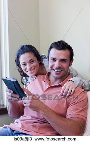 Young couple using electronic book, portrait View Large Photo Image Stock Image - Young couple using electronic book, portrait. Fotosearch