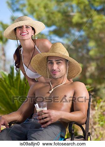 Young couple wearing sun hats and relaxing on vacation, portrait View Large Photo Image Stock Image - Young couple wearing sun hats and relaxing on vacation, portrait. Fotosearch