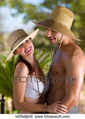 Young couple wearing sun hats and relaxing on vacation, portrait View Large Photo Image Stock Photo - Young couple wearing sun hats and relaxing on vacation, portrait. Fotosearch