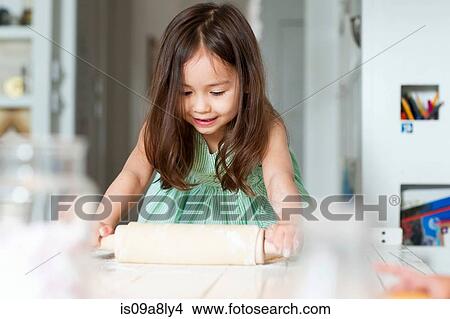Young girl rolling out pastry on kitchen counter View Large Photo Image Picture - Young girl rolling out pastry on kitchen counter. Fotosearch