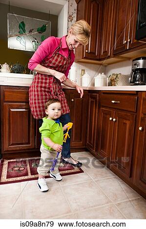 Young male toddler and grandmother in kitchen View Large Photo Image Stock Photo - Young male toddler and grandmother in kitchen. Fotosearch