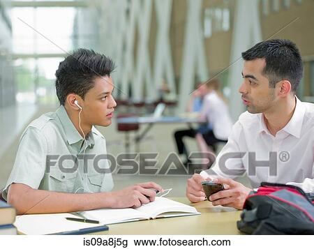 Young man studying with mid adult tutor View Large Photo Image Stock Image - Young man studying with mid adult tutor. Fotosearch