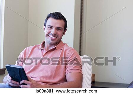 Young man using electronic book, portrait View Large Photo Image Stock Image - Young man using electronic book, portrait. Fotosearch