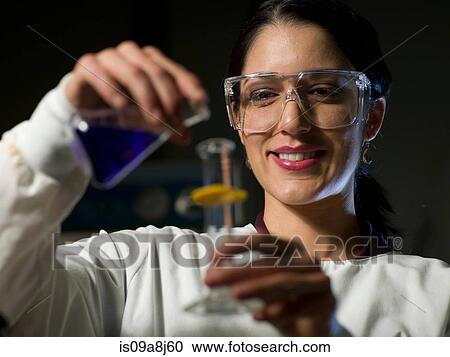 Young scientist in safety glasses mixing chemicals, smiling View Large Photo Image Stock Image - Young scientist in safety glasses mixing chemicals, smiling. Fotosearch