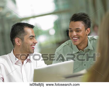 Young student looking at laptop with mid adult tutor, smiling View Large Photo Image Stock Image - Young student looking at laptop with mid adult tutor, smiling. Fotosearch