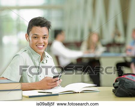 Young student wearing earphones and holding mp3 player, portrait View Large Photo Image Stock Image - Young student wearing earphones and holding mp3 player, portrait. Fotosearch