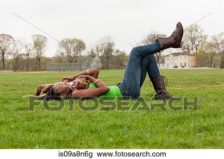 Young woman and her dog playing on grass View Large Photo Image Stock Image - Young woman and her dog playing on grass. Fotosearch