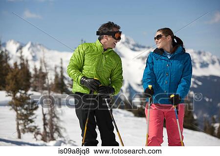 Young woman and mature man in skiwear holding ski poles View Large Photo Image Stock Photo - Young woman and mature man in skiwear holding ski poles. Fotosearch