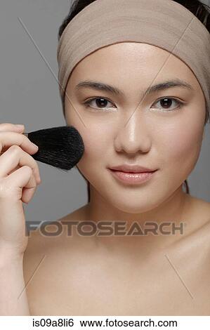Young woman applying blusher View Large Photo Image Stock Photograph - Young woman applying blusher. Fotosearch