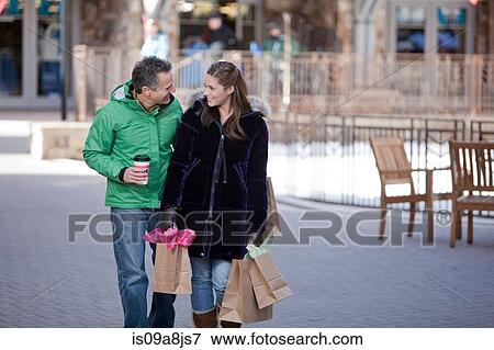 Young woman carrying shopping bags with mature man View Large Photo Image Stock Photo - Young woman carrying shopping bags with mature man. Fotosearch